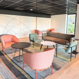 a lounge area with a couch, tables and chairs