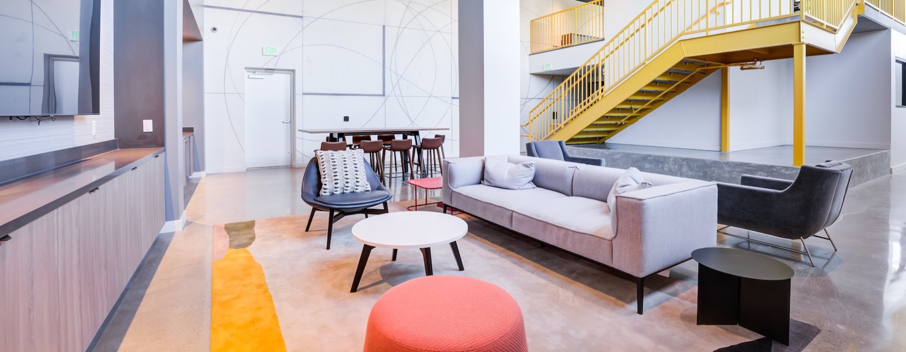 a lounge area with a couch, tables and chairs